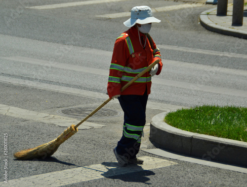 Street sweeper in orange garb with cleaning broom, Beijing, China 