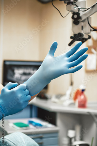Dentist wears surgical gloves while preparing for check-up