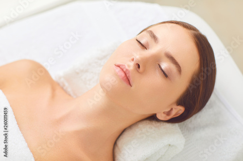 Beauty and spa concept. Brunette girl lying on a massage desk