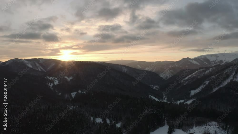 Aerial shot of winter sunset over mountains on sunny day Aerial shot of winter sunset over mountains on sunny day