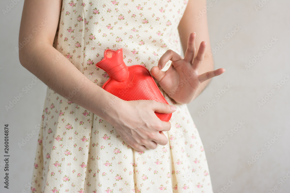 Close up woman has abdominal pain, woman's belly with hot water bottle,Close up woman use Hot Pack Close up woman has abdominal pain, woman's belly with hot water bottle,Close up woman use Hot Pack