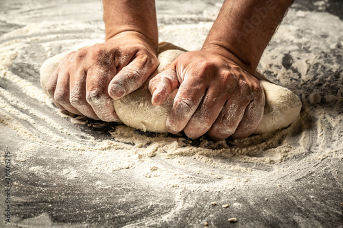 Making dough by male hands at bakery. Food concept photo