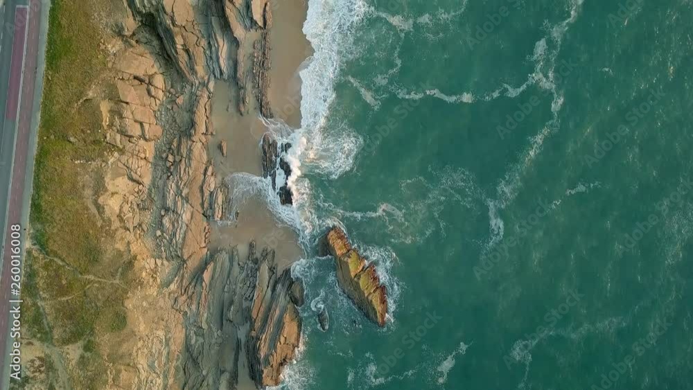 Top-down aerial view of waves crashing into the rocky Portuguese coast. Top-down aerial view of waves crashing into the rocky Portuguese coast.
