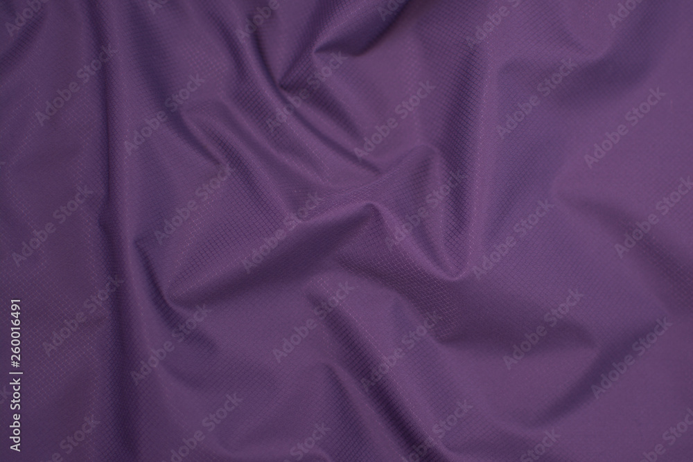 Fototapeta premium Silk crumpled fabric purple. View from above. Textile and texture concept - close up of crumpled silk violet wavy fabric background
