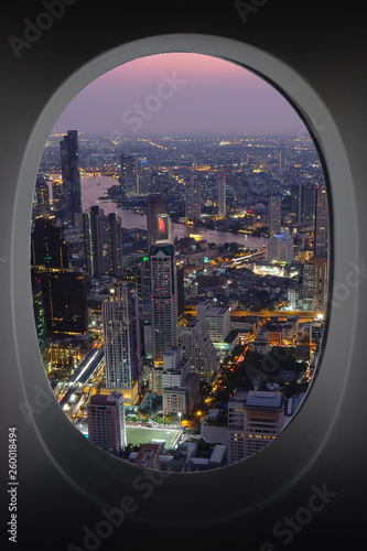 sunset cityscape of Bangkok  through window of aircraft