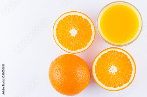 Orange fruits with juice  concept. Orange juice and halves of oranges on white background. Citrus for making juice. Whole and squeezed oranges and glass of juice