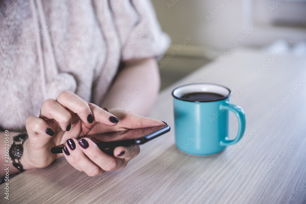 Fototapeta premium Woman with beautiful purple polished nails and a bracelet typing on her phone