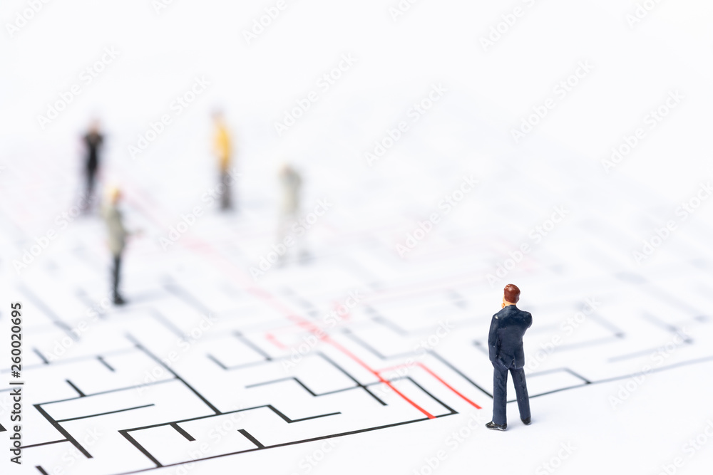 Miniature people, businessman in the labyrinth or maze figuring out the way out. Business concept, finding solution, strategic, and business opportunity. Miniature people, businessman in the labyrinth or maze figuring out the way out. Business concept, finding solution, strategic, and business opportunity.