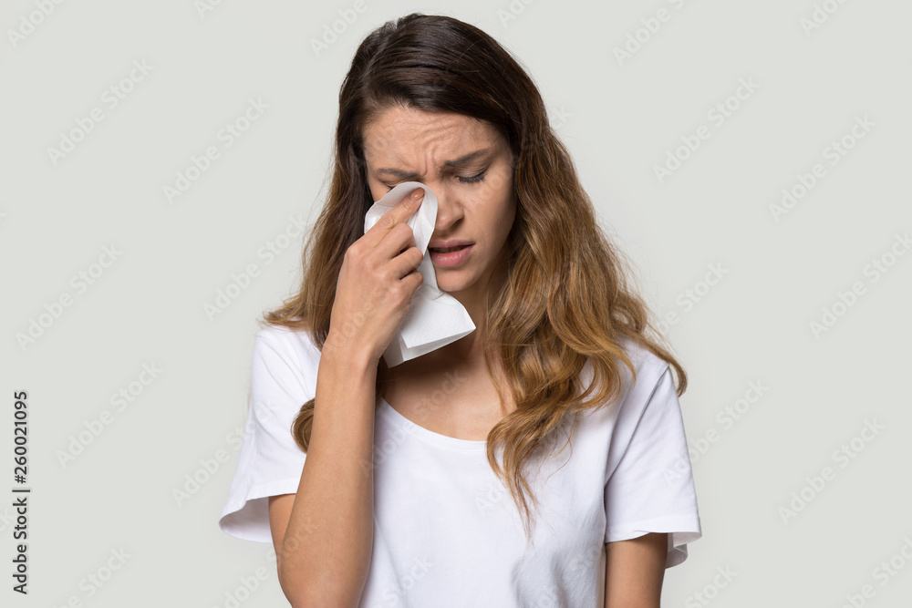 Unhappy young woman holding tissue wiping tears studio shot Unhappy young woman holding tissue wiping tears studio shot