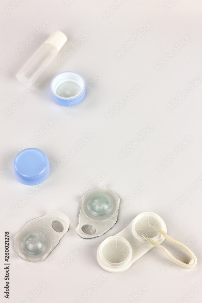 Contact lenses, case and tweezers on white background. Eye health and care, eyesight and vision, ophthalmology and optometry Contact lenses, case and tweezers on white background. Eye health and care, eyesight and vision, ophthalmology and optometry