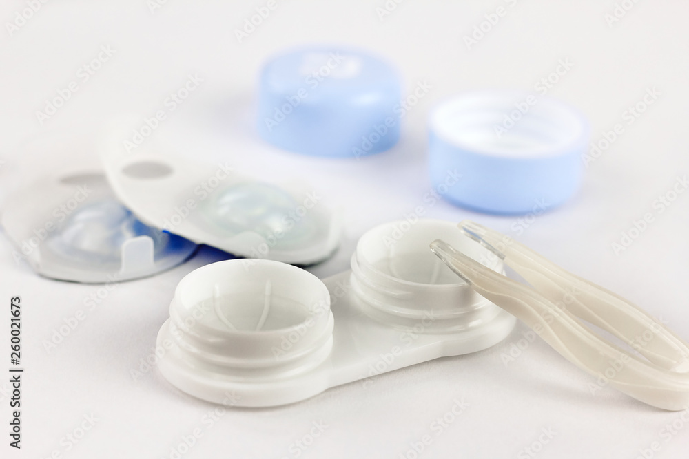 Contact lenses, case and tweezers on white background. Eye health and care, eyesight and vision, ophthalmology and optometry Contact lenses, case and tweezers on white background. Eye health and care, eyesight and vision, ophthalmology and optometry