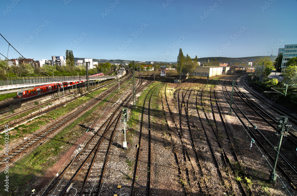 Railway tracks and moving train outside near a big train station Railway tracks and moving train outside near a big train station