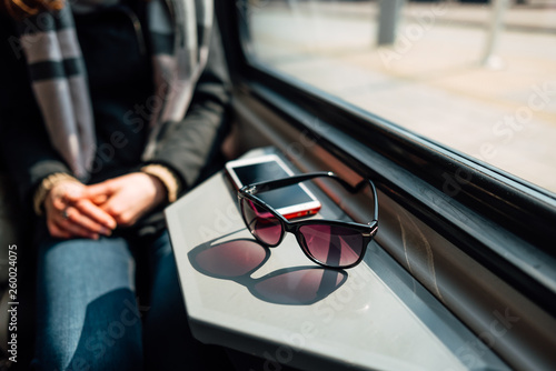 Fashionable sunglasses and smartphone lie on metal table. photo