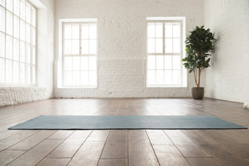 Fototapete Yogaschule Unrolled yoga mat on wooden floor in yoga studio  © fizkes