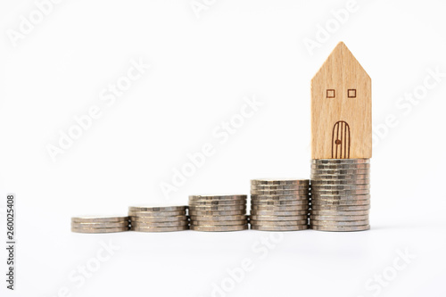 House model on coins stack. Concept for property ladder, mortgage and real estate investment . photo