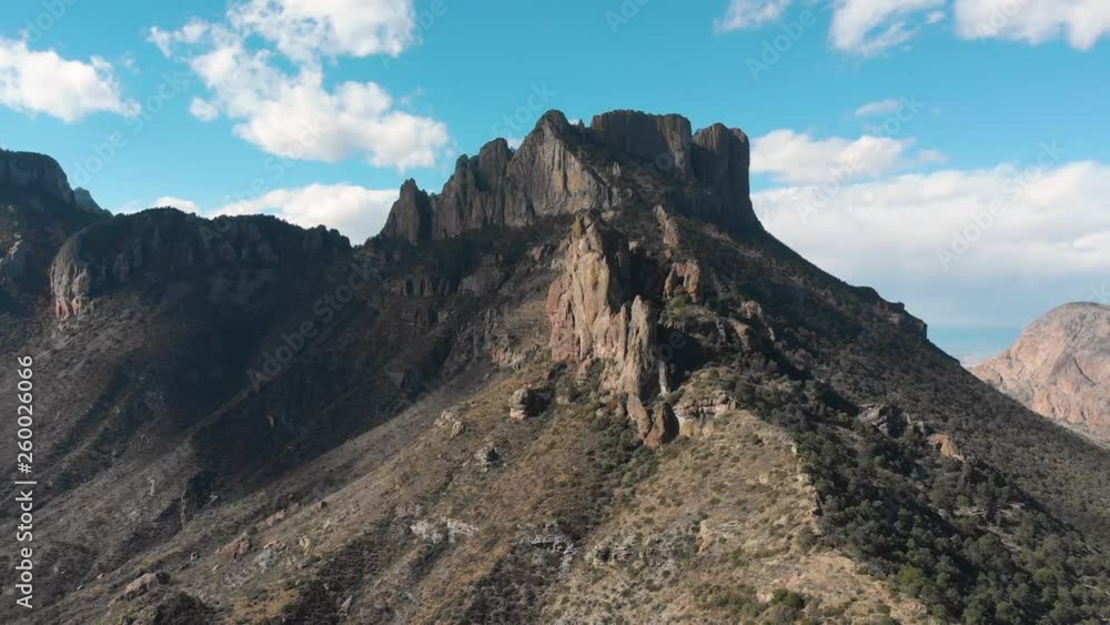 Pull back aerial shot at Chisos basin, as shadows from clouds crawl across the mountain ridge Pull back aerial shot at Chisos basin, as shadows from clouds crawl across the mountain ridge