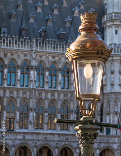 Vintage street lamp with the Gothic  Brussels Town Hall in the background on the famous Grand Place in Brussels, Belgium. photo