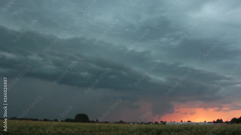 Combination of two different weathers in the background - storm and a lightning on the left side, and a calm, colorful sunset on the right. Combination of two different weathers in the background - storm and a lightning on the left side, and a calm, colorful sunset on the right.