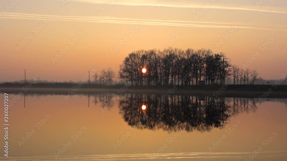 Beautiful timelapse of a sunset reflecting in the lake. The sky is slowly changing its colour from orange to navy blue. Beautiful timelapse of a sunset reflecting in the lake. The sky is slowly changing its colour from orange to navy blue.