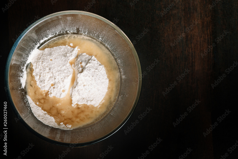 Baking ingredients mixed in a glass bowl. Preparation for kneading dough Baking ingredients mixed in a glass bowl. Preparation for kneading dough