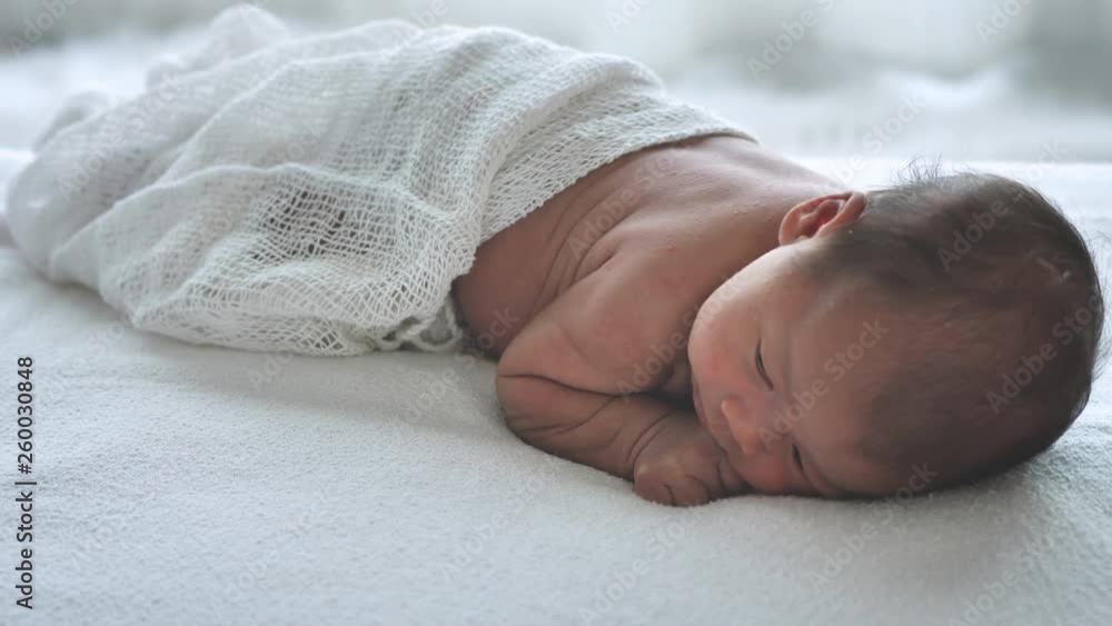 Asian female newborn baby face down lying in bed and sunlight in the ...