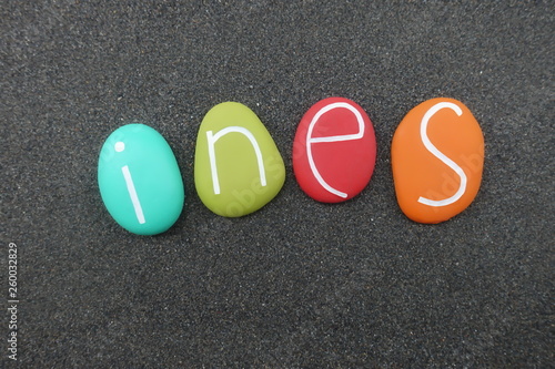 Ines, feminine given name with colored stones over black volcanic sand