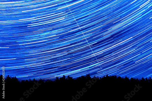 Wonderful beautiful night sky star trail over the river and forest in transparent april night