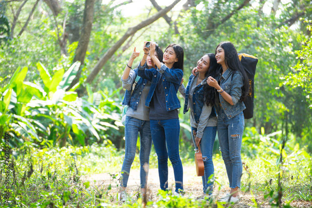 Asian female teenager group walking in the forest amid the green nature of trees and shrubs. Asian female teenager group walking in the forest amid the green nature of trees and shrubs.
