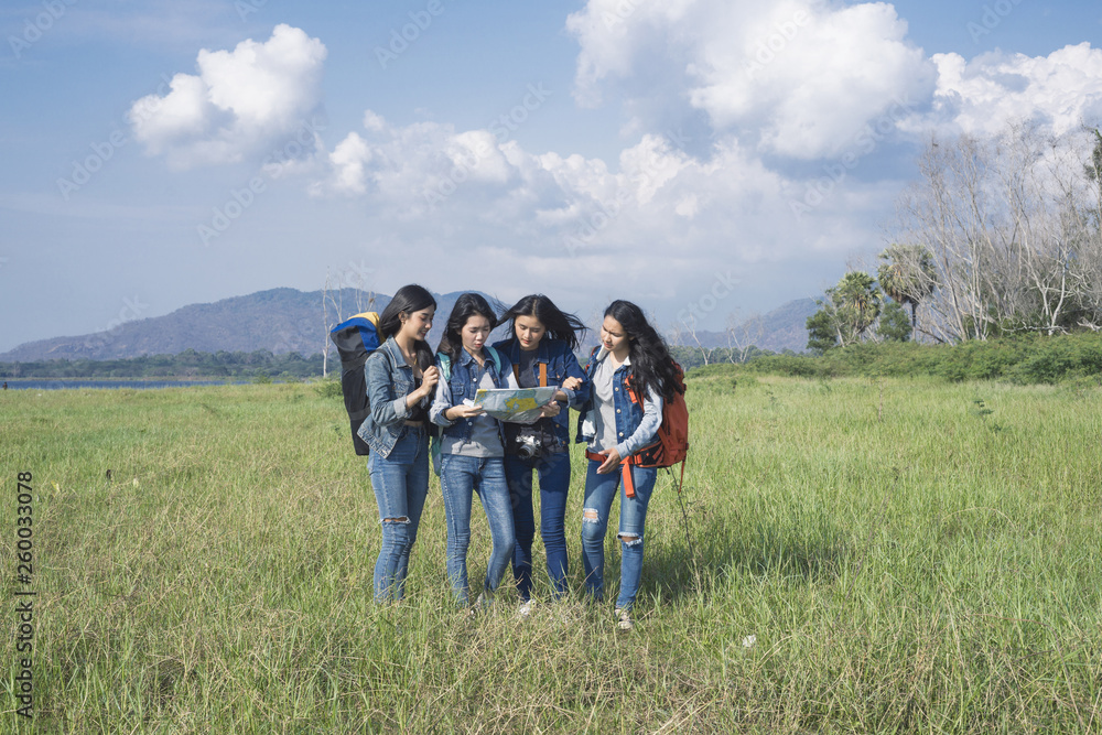 A group of tourists who are stopping to see the map amidst lush green fields.
