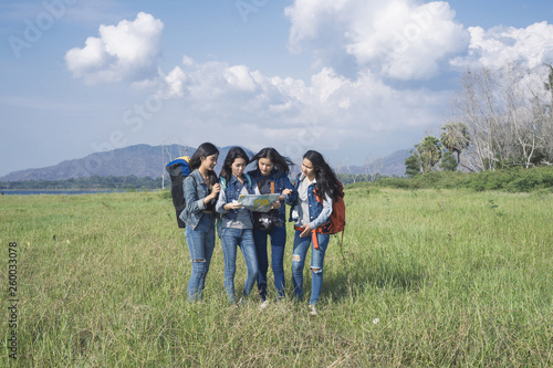 A group of tourists who are stopping to see the map amidst lush green fields.