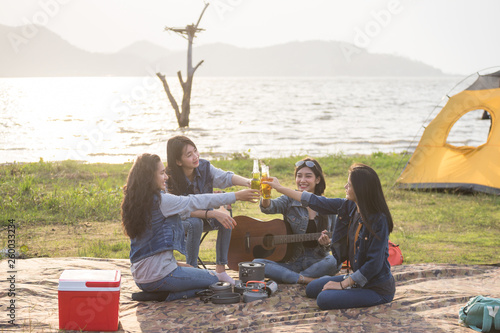 group of girls are camping near the reservoir for relaxing and party.
