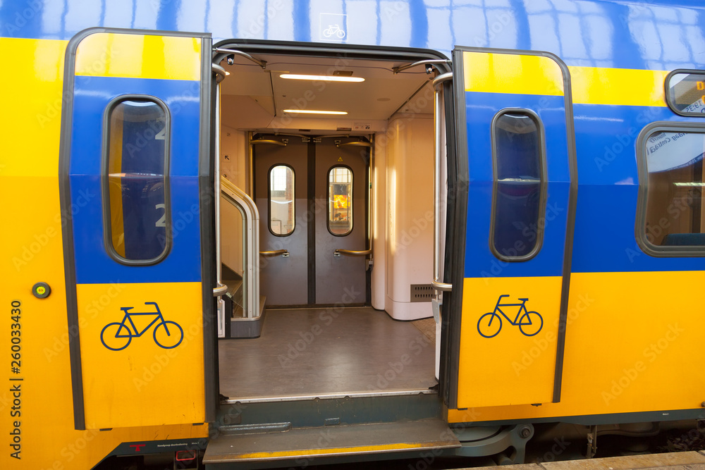 AMSTERDAM, THE NETHELANDS : Yellow-blue wagon of traditiona trains in Holland. Door for bike.