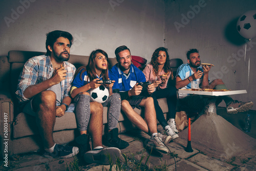 Group of friends playing a football video game photo