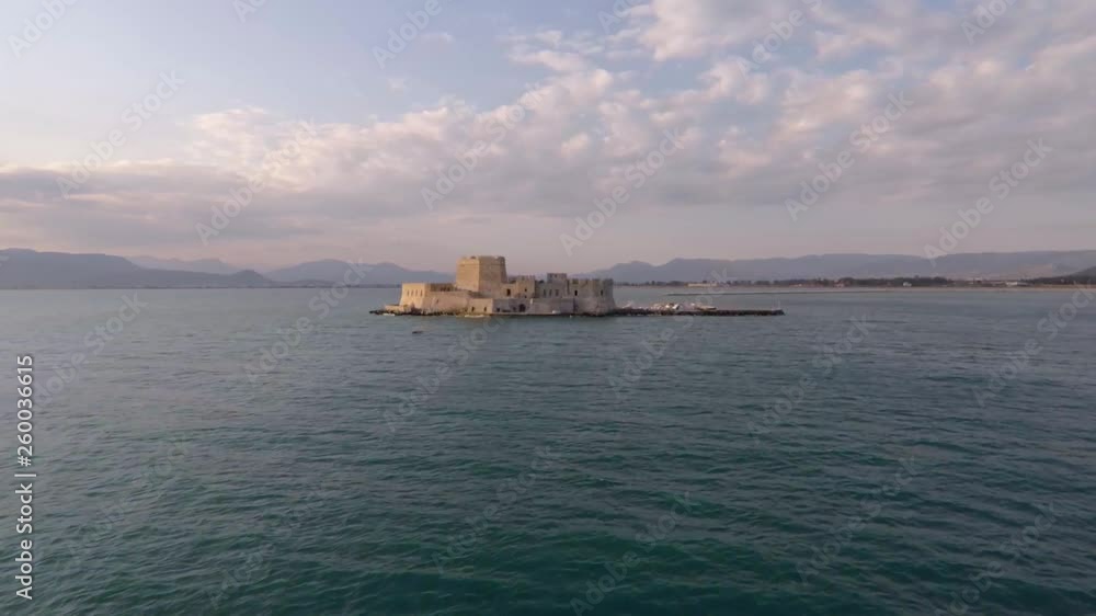 Drone shot above sea approaching Bourtzi castle in Nafplio - Greece
