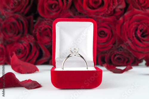 Wedding ring in a cool velvet box against a background of roses