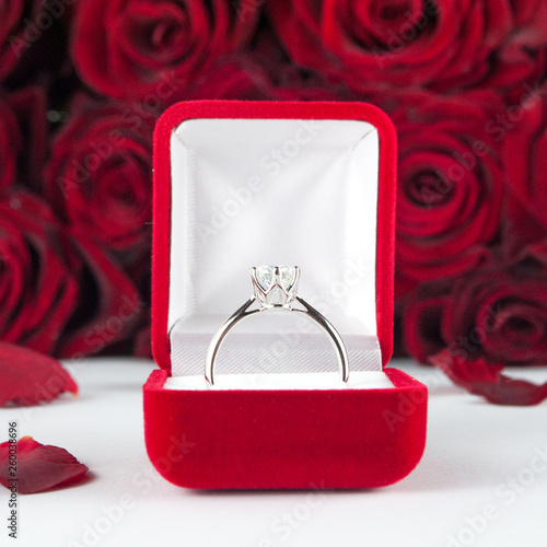 Wedding ring in a cool velvet box against a background of roses