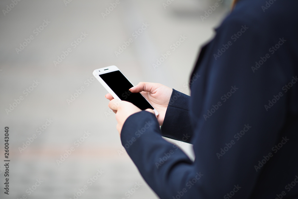 The business lady uses a smartphone on the street The business lady uses a smartphone on the street