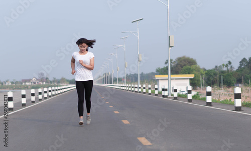 Close up asian woman running on the road at morning, selective focus
