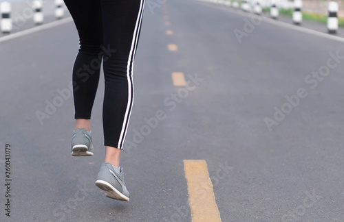 Close up woman legs running on the road at morning, selective focus