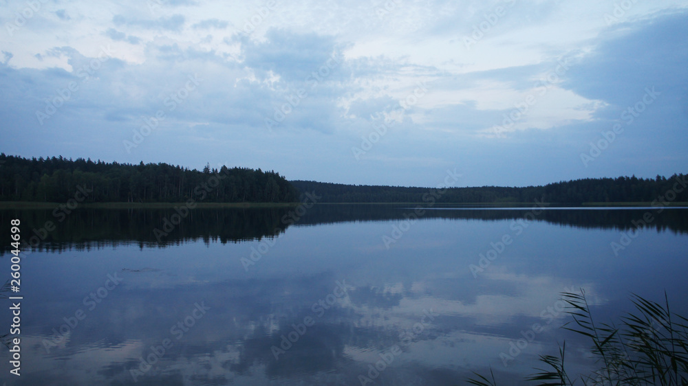 Blue transparent lake in the forest in the late evening.
