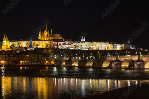 The Prague castle with historic Charles Bridge and Vltava river in the night scene with water reflection. Prague is a popular travel destination. Prague, Czech Republic