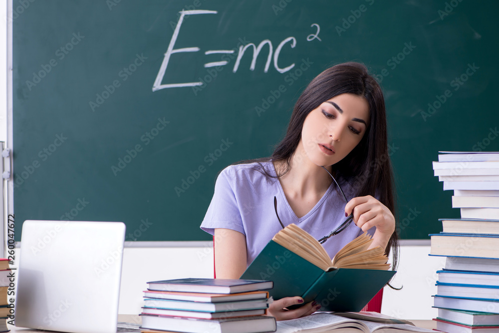 Young female teacher student in front of green board Young female teacher student in front of green board