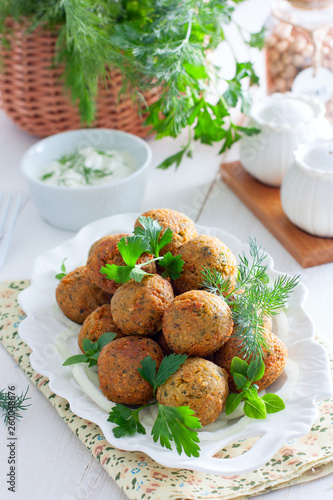 Chickpea falafel with fresh herbs on a white plate, selective focus