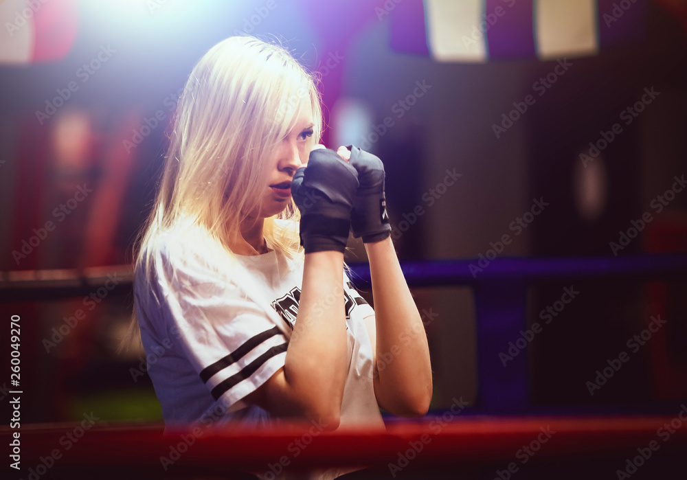 Beautiful sports girl on a street workout. Young beautiful female boxer portrait at gym.light blur Beautiful sports girl on a street workout. Young beautiful female boxer portrait at gym.light blur