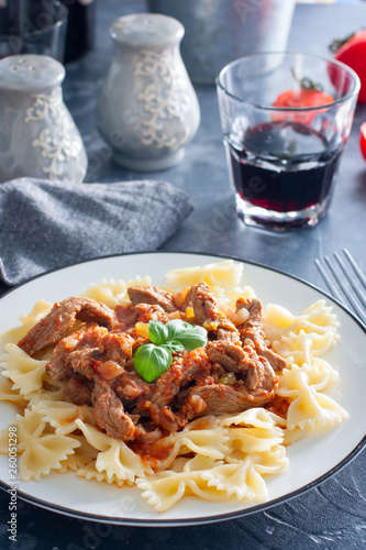 Beef in tomato sauce with farfalle, selective focus
