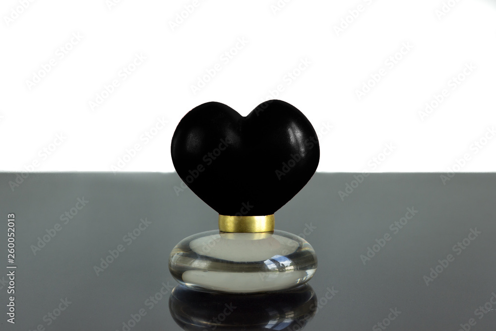 black heart on a ring on a shiny surface isolated on white