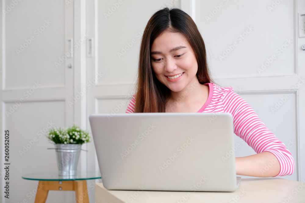 Young asian woman using laptop computer and smiling with happiness , people and technology, lifestyles, education, business concept Young asian woman using laptop computer and smiling with happiness , people and technology, lifestyles, education, business concept