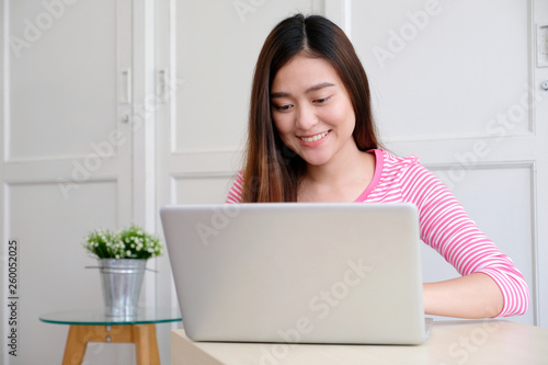 Young asian woman using laptop computer and smiling with happiness , people and technology, lifestyles, education, business concept