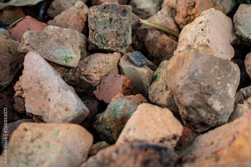 Pile of orange rough stones on ground for background, wallpaper