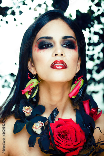 pretty brunette woman with rose jewelry, black and red, bright make up kike a vampire closeup red lips photo